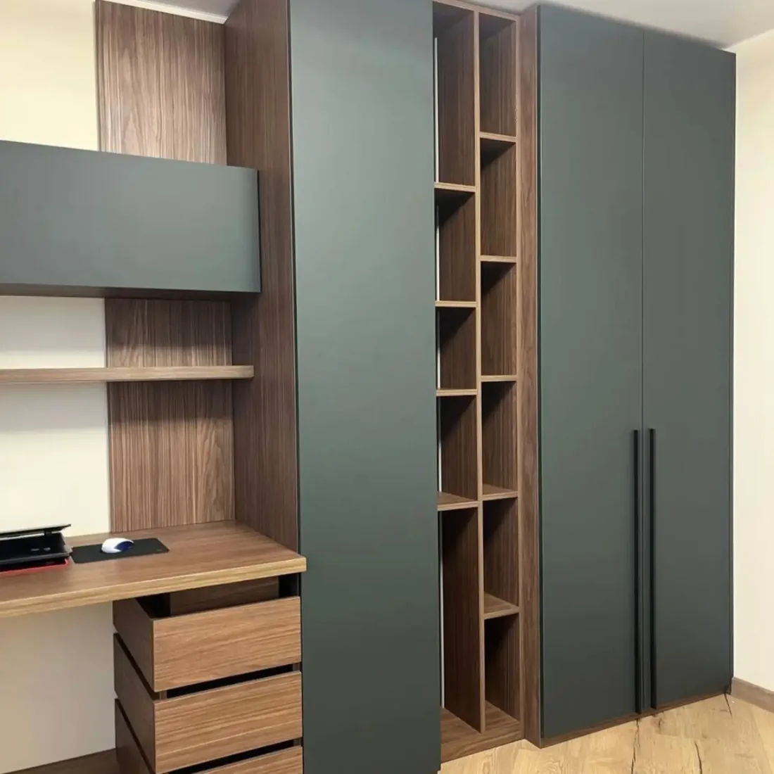 Home office planejado com armário verde, nichos e bancada de trabalho em madeira